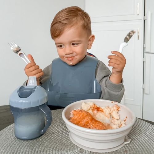 dreng der spiser fra sin bambino skål med sugekop