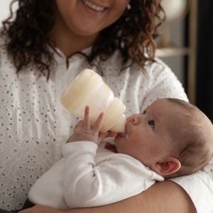 lille baby der drikker fra sin mam sutteflaske