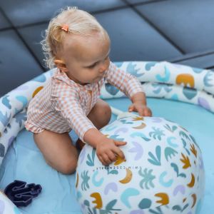 Barn i pool der leger med en badebold fra swim essentials