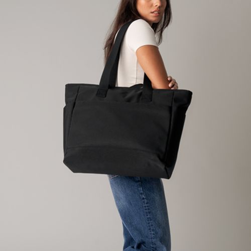 kvinde der bærer sort shopper taske