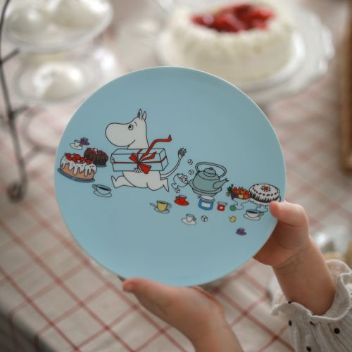 barn der holder en lyseblå mumi tallerken