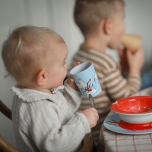 barn der drikker af mumi krus