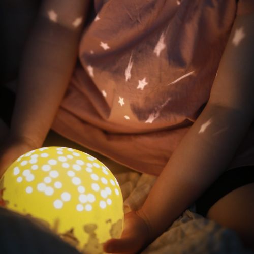 barn der holder en mumi natlampe, der lyser stjerner.